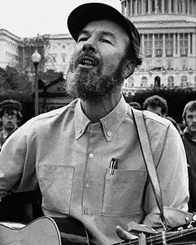 Folk singer Pete Seeger holding guitar and singing