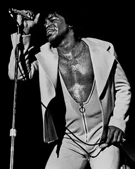James Brown standing singing into microphone
