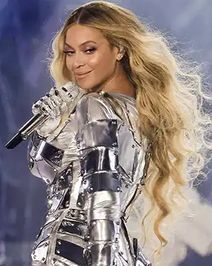 Beyonce smiling wearing silver outfit