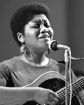 Folk singer Odetta holding guitar and singing