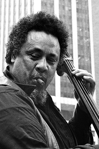 Charles Mingus playing bass with cigar in mouth